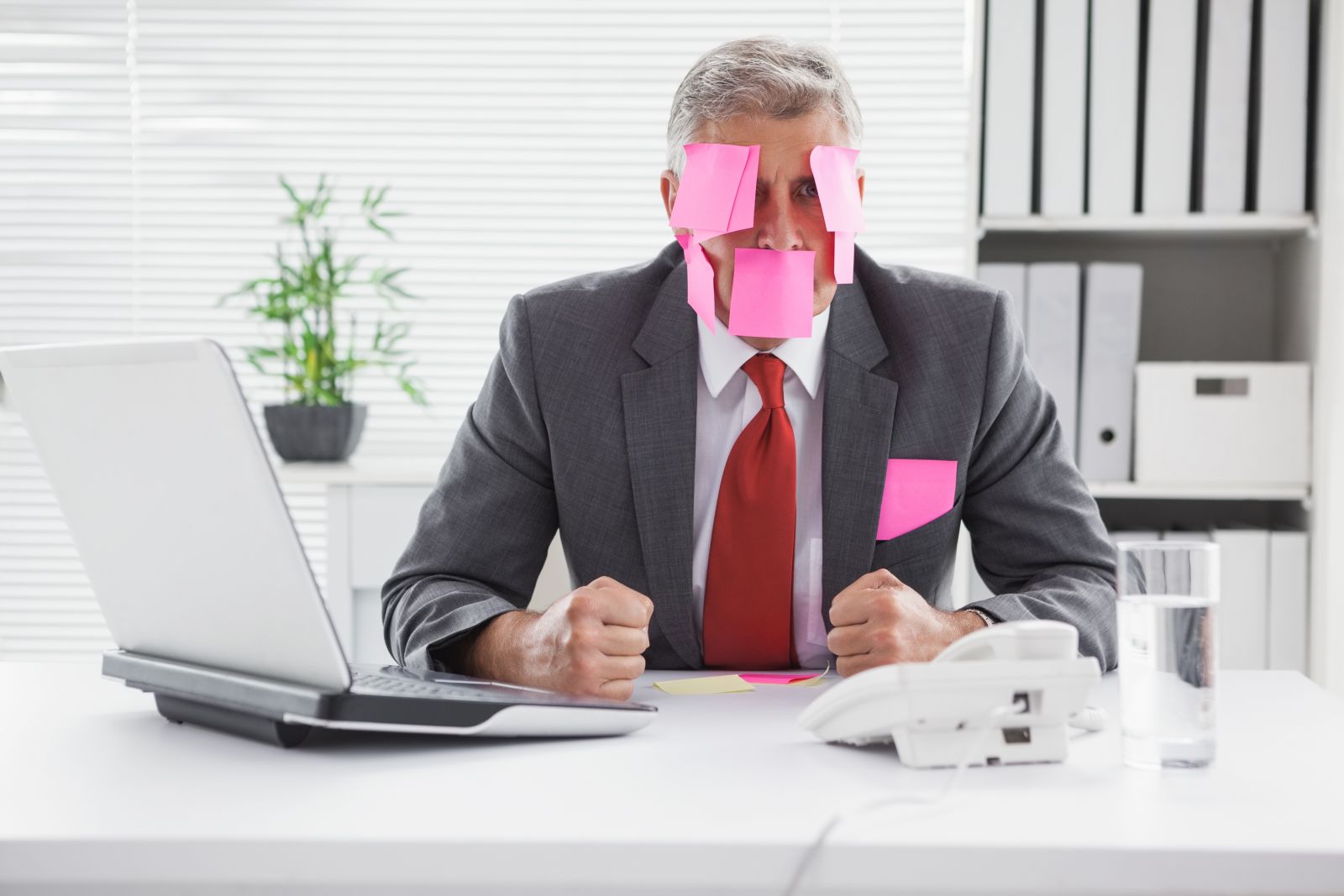 overwhelmed businessman covered in sticky notes