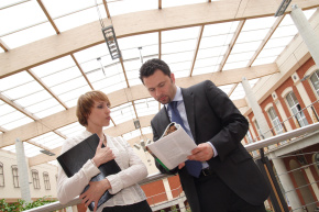 business man and woman reading news in magazine