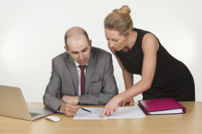 Image of a female executive explaining something to her boss in office.