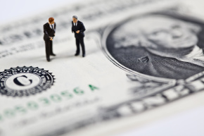 Businessmen standing on dollar bill