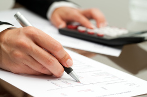 Extreme close up of female hand with pen pointing on cash flow document.