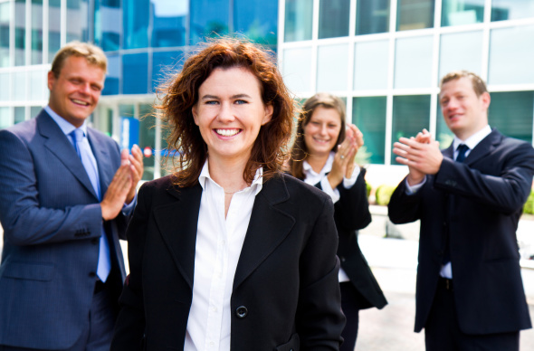 Businesswoman being applauded by peers