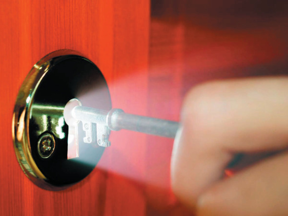 hand using key to unlock door