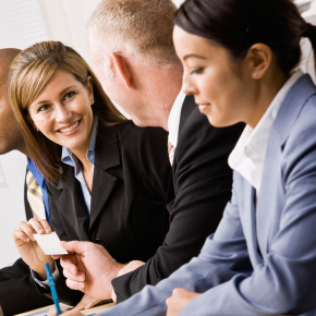 Confident businesswoman handing man a business card in networking session
