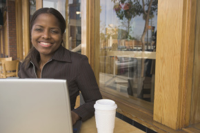 Businesswoman working on laptop at cafe.