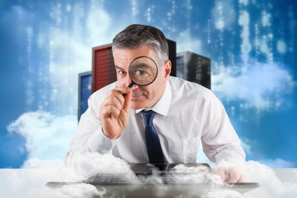 Businessman holding up magnifying glass