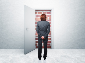 Businesswoman opens door to brick wall