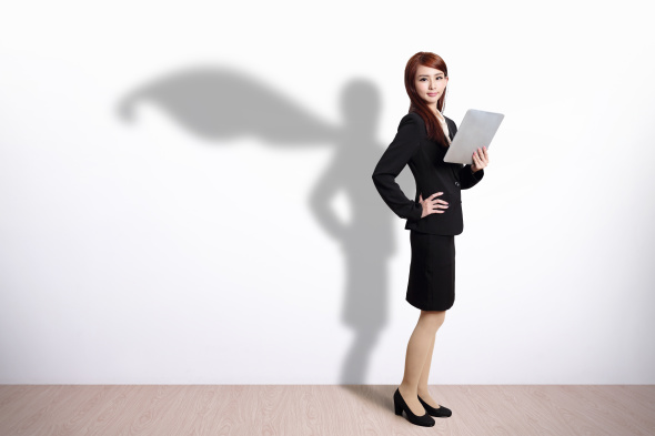 Superhero businesswoman wearing shadow cape