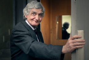 Elderly businessman with hand on door frame