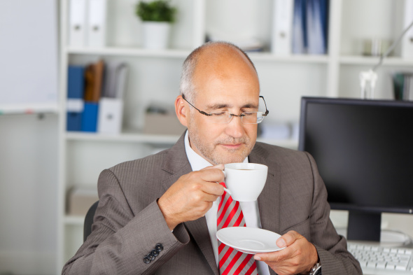 Older businessman taking a coffee break