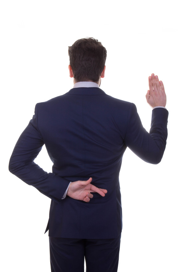 Businessman with fingers crossed behind back