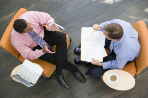 Overhead view of two businessmen meeting in lobby