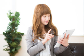 Businesswoman typing on tablet