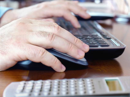Man's hands on computer keyboard