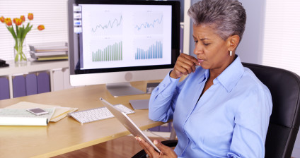 Senior businesswoman using tablet and desktop computers