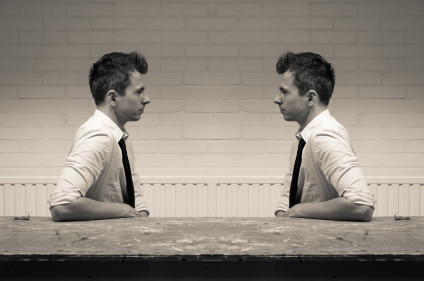 Young man facing image of himself