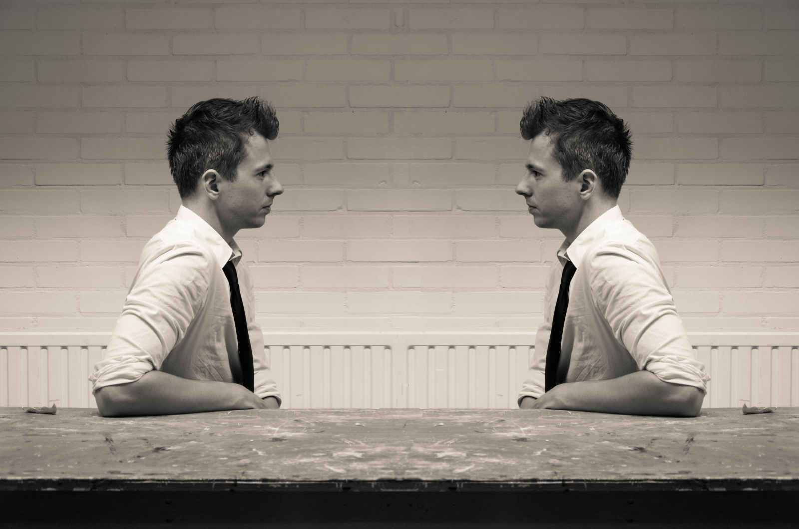 Young man facing image of himself