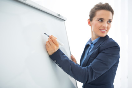 Closeup of businesswoman writing on a flipchart