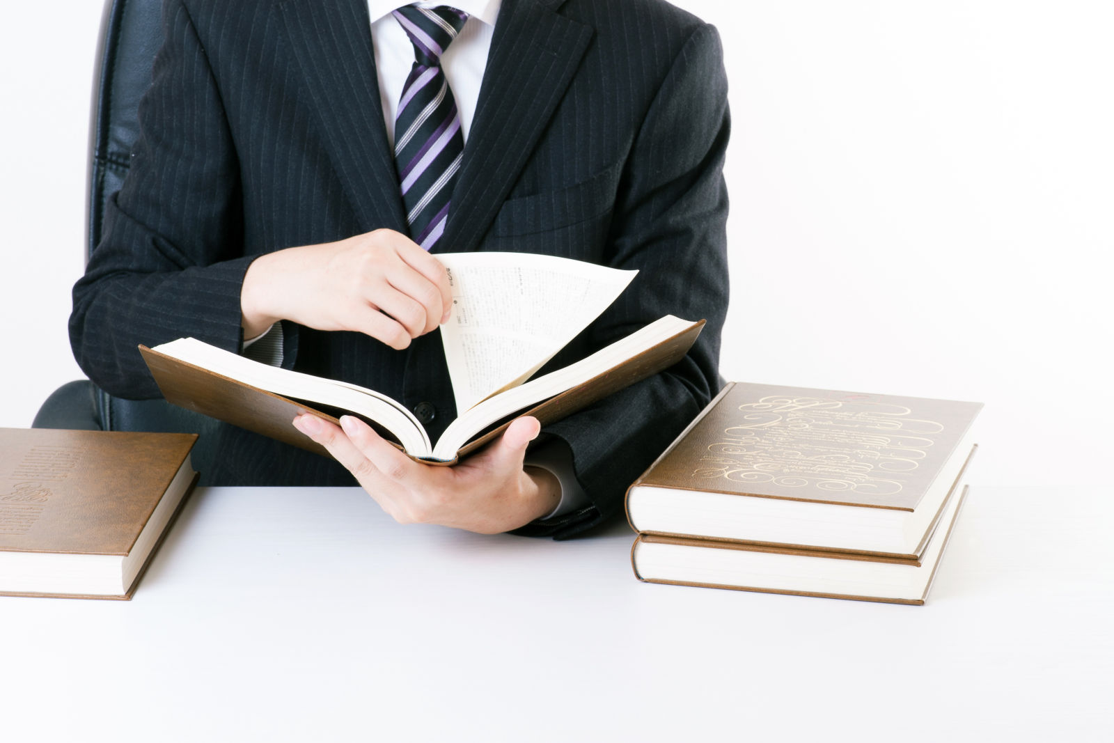 Businessman looking up answers in a book