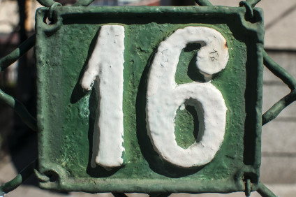 Green cast iron sign with white 16 painted on it
