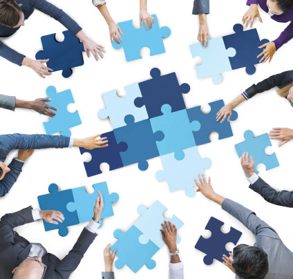 Overhead view of people solving a large jigsaw puzzle