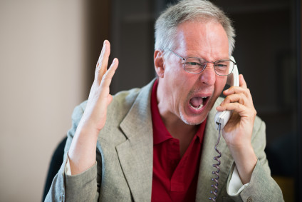 Portrait of an angry man yelling on the phone
