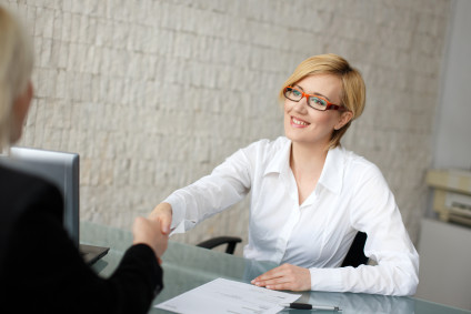 Woman and man shaking hands across a desk