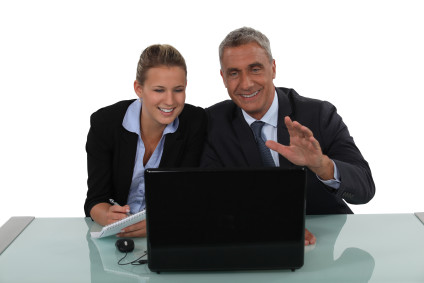 Younger businesswoman and older businessman working together