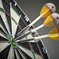 Three darts hitting a target bull's-eye