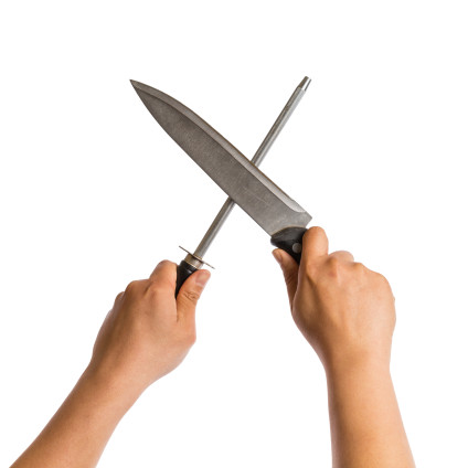 Two hands honing a large knife