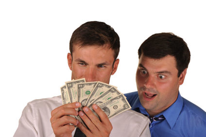 Businessman ogling money over another's shoulder