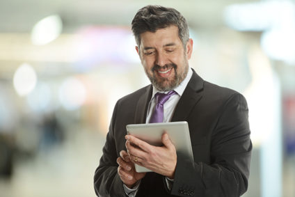 Mature businessman holding an electronic tablet inside an office building