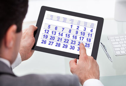 Businessman looking at calendar on tablet