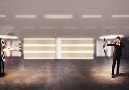 Businessman shooting arrows at target