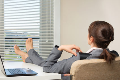 Businesswoman relaxing in the office with bare feet up on her desk