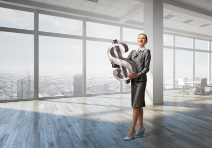 Businesswoman holding giant dollar symbol