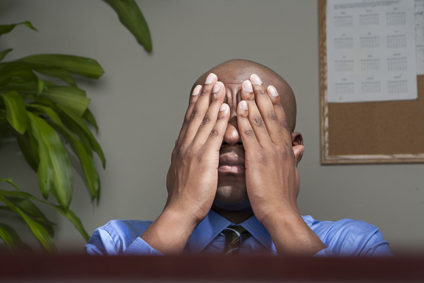 Businessman covering face with hands