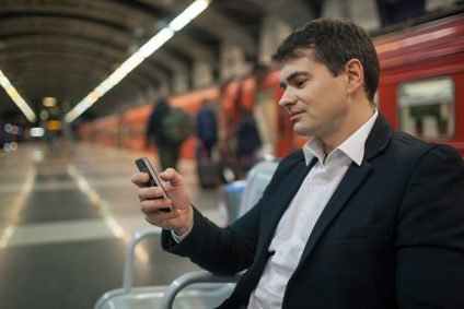 Businessman using smartphone while waiting at a subway station