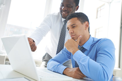 Businessman explaining something on laptop to another man