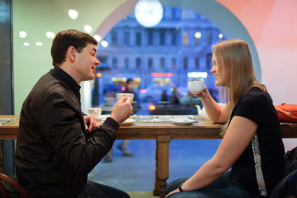 Man and woman chatting over a cup of coffee inside a cafe or restaurant