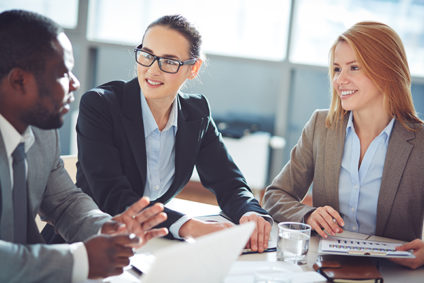 Man and two women talking in office