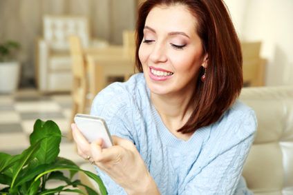 Smiling woman using smartphone