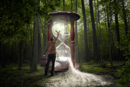 A man tries to fix a broken hourglass in the forest