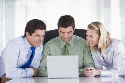 Three happy businesspeople looking at laptop