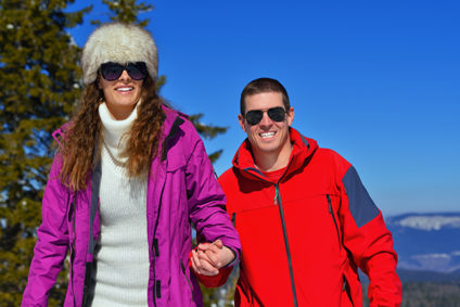 Young couple holding hands on winter hike with mountain in background