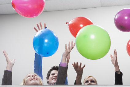 People in office releasing balloons