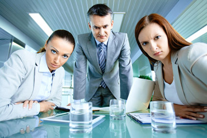 Three office workers glaring at camera