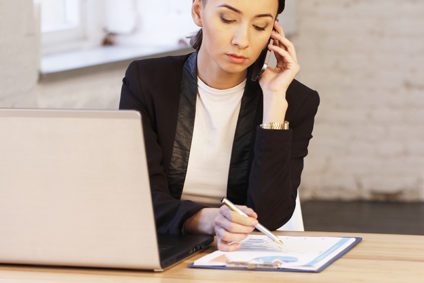 Businesswoman speaking on phone in office