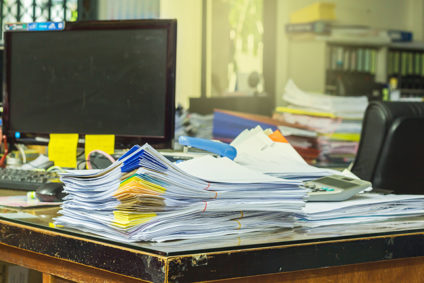Stacks of papers on the corner of a desk