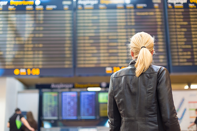 Woman checking a departure board at an airport